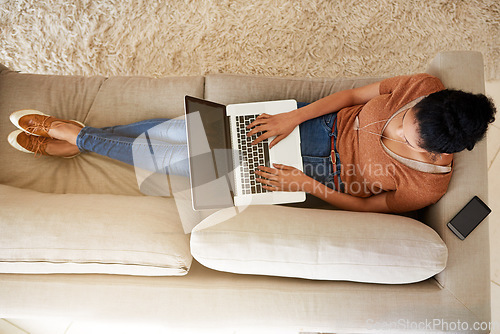 Image of Top view of woman on couch with laptop, typing for blog and freelance copywriter working from home. Female freelancer in living room, copywriting and writing on pc with technology and remote work