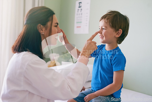 Image of Woman doctor, playing and child fun at a hospital for healthcare and medical consultation. Smile, trust and pediatrician touch nose with a laugh and happiness in a clinic with boy patient with exam