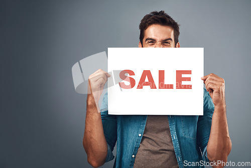 Image of Man, sale and billboard poster for advertising, marketing or branding against a grey studio background. Male person or realtor holding board or sign for sales announcement, notice or advertisement