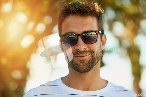 Image of Confidence, sunglasses and portrait of a man in a park while on a summer vacation, weekend trip or holiday. Smile, happy and face of a young male person from Brazil standing in an outdoor garden.