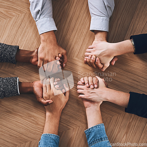 Image of Above, partnership or business people holding hands for support, teamwork or strategy in office. Motivation, zoom or employees in group collaboration with diversity or mission for goals together