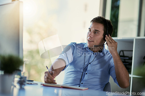 Image of Callcenter agent, smile and notes, man consulting with advice, sales information and help desk. Phone call, conversation and customer support consultant writing in notebook while speaking in office.