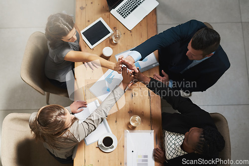 Image of People, high five and business meeting success at table with documents above for teamwork at office. Top view of group hands in solidarity or motivation for team building, agreement or collaboration