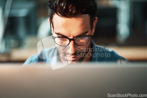 Image of Serious man, face and glasses at computer in office for planning software update, online research and data analysis. Focused developer, desktop and internet connection for business, website or coding