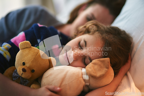 Image of Young girl, mother and sleeping with teddy bear in bed with love and bonding. Kid, mom and dream together in the morning with daughter and mama in a family home feeling relax, calm and rest in house