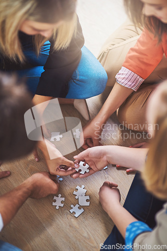 Image of Top view, people and puzzle for teamwork, support and problem solving of challenge, synergy and cooperation. Group of hands planning jigsaw for integration, collaboration and solution for innovation