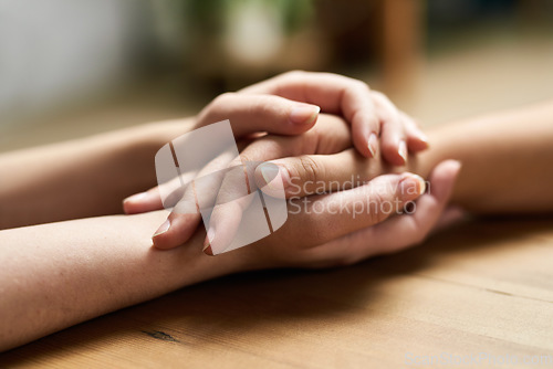 Image of Comfort, holding hands and support of friends, care and empathy together on table after cancer. Kindness, love and women hold hand for hope, trust or prayer, solidarity or compassion, help or unity.