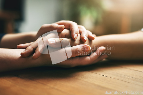 Image of Holding hands, counseling and support of friends, care and empathy together on table after cancer. Kindness, love and women hold hand for hope, trust or prayer, comfort or compassion, help or unity.