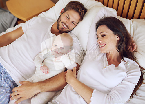 Image of Top view of mother, father and baby on bed for love, care and quality time together. Happy parents, family and newborn kid relaxing in bedroom with support, childhood development and bonding at home