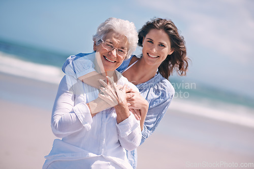 Image of Portrait, young woman and hug her senior mother or smile or on the beach and together outdoors. Senior citizen, happy family and embracing with adult daughter or peace or freedom at sea for travel