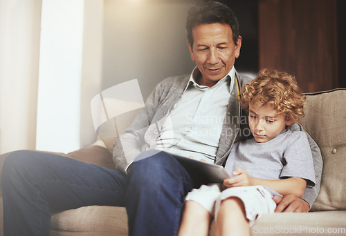 Image of Tablet, child or grandfather streaming movie or film on online subscription in retirement at home to relax. Bond, grandparent or kid loves watching fun videos with a senior or mature old man on sofa