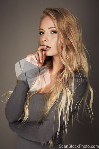 Image of Young woman, portrait and cosmetic in studio background for dermatology and wellness in a bodysuit. Girl, model, face and glow with healthy body and makeup for beauty and confidence with hair.