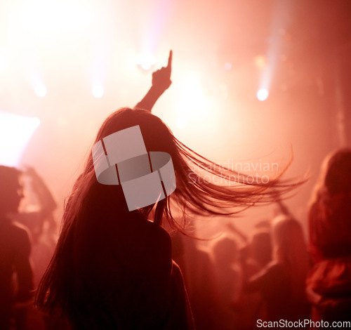 Image of Dancing, club and back of woman at a concert, disco event or psychedelic trance festival. Night, energy and female person doing dance or moving to a song with red light at techno party or show.