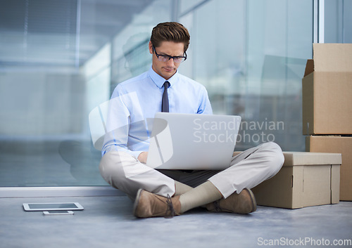 Image of Moving boxes, office laptop and man reading business report, online information or search web, internet or website info. Relocation, cardboard box and male worker, employee or person sitting on floor