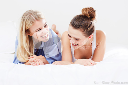 Image of Funny, relax and friends in bed laughing together as happiness isolated in a studio white background. Smile, happy and female people or women laugh at a joke and feeling excited in a bedroom