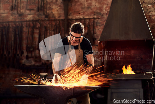 Image of Blacksmith, man and metal workshop and sparks, manual forge working on hot steel with hammer, and fire. Worker, person welding or iron tools manufacturing and expert, trade and dark workspace