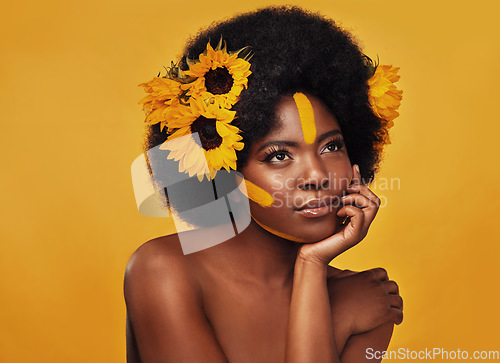 Image of Beauty, sunflower and black woman thinking in studio for makeup, wellness and treatment on yellow background. Flower, skincare and African female model relax, pose or contemplate natural cosmetics