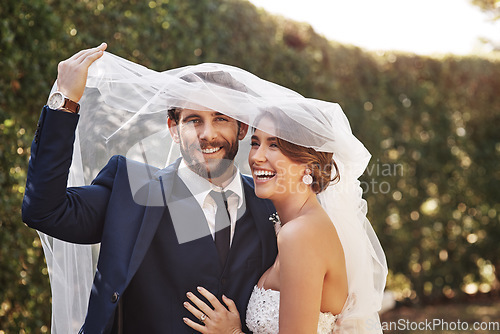 Image of Wedding, veil and couple with love, marriage and celebration for relationship, loyalty and commitment. Portrait, bride or groom with a smile, married or cover with dress with happiness in a garden