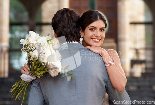 Image of Flowers, wedding and love with a married couple hugging outdoor together after a ceremony of tradition. Hug, marriage or commitment with a man and woman outside looking happy as husband and wife