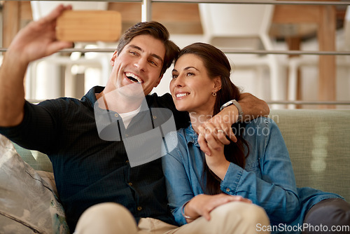 Image of Couple, sofa and selfie in home for smile, holding hands or pride for love, care or internet app. Man, woman and happy for photography, profile picture or social media for bond, relax or lounge couch