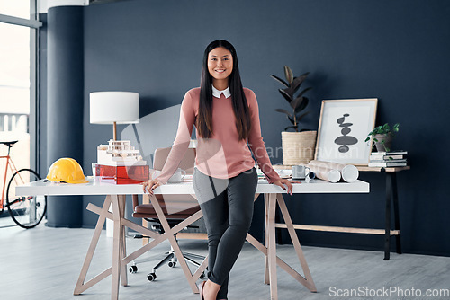 Image of Portrait, architect and asian woman in office with engineering plan, blueprint and construction helmet. Face, female worker in professional architecture company workplace with confidence and smile