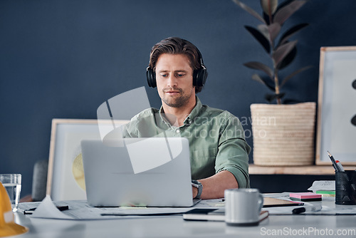 Image of Music headphones, man and architect on laptop in office streaming radio podcast. Computer, audio or male designer listening to sound or song and working on design, research or engineering floor plan