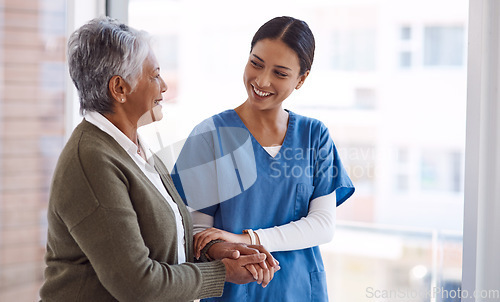 Image of Support, caregiver with senior woman and holding hands for care indoors. Retirement, consulting and professional female nurse with elderly person smiling together for healthcare at nursing home