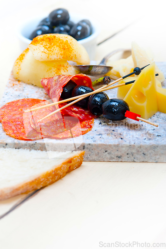 Image of mix cold cut on a stone with fresh pears