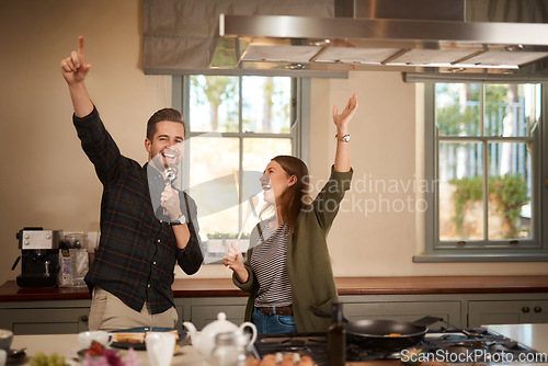 Image of Food, sing and a funny couple in the kitchen of their home, having fun together while cooking. Karaoke, comic or silly with a man and woman laughing while singing over breakfast in their house