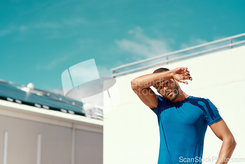 Image of Sports, fitness and sweat, man with blue sky at outdoor gym for health and wellness with mockup space. Workout, exercise and tired athlete with focus, fatigue and healthy mindset for fit summer goals