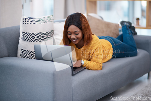 Image of Black woman, typing on laptop and relax on couch with internet search, blog and communication while at home. African female blogger in apartment, connectivity and writing on pc with browsing online