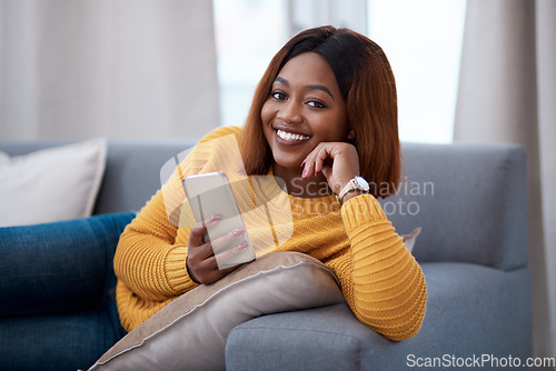 Image of Black woman using phone, chat on social media and relax at home, smile in portrait with online communication. African female person, mobile app with text or post update with connectivity in apartment