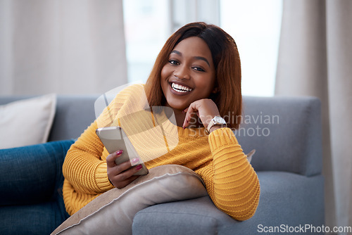 Image of Black woman using phone, chat on social media and laughing, relax at home with smile in portrait. African female person, app with text and funny meme with connectivity and communication in apartment