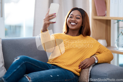 Image of Black woman, happy in selfie and relax on couch in lounge, lifestyle influencer at home and social media post. African female content creator in apartment, smile in picture and communication on app