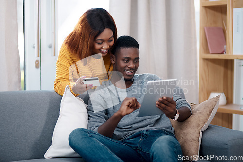 Image of Tablet, credit card and a black couple online shopping on a sofa in the living room of their home together. Ecommerce, bank or payment with a man and woman customer in a house to shop on the internet