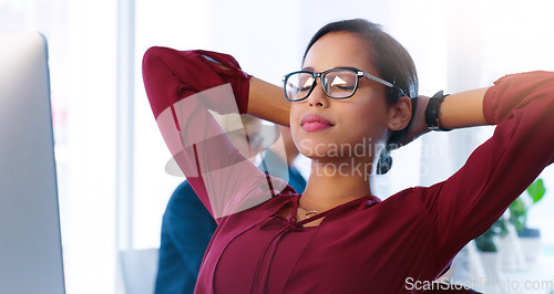 Image of Relax, computer and a business woman done with her tasks for the day in an office with hands behind her head. Resting, flare and complete with a young female employee working online using a desktop