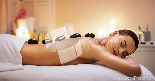 Image of Relax, hot stone and woman getting a massage at a spa for healing, health and wellness. Self care, beauty and female person getting a natural, body care and luxury back therapy or treatment at salon.