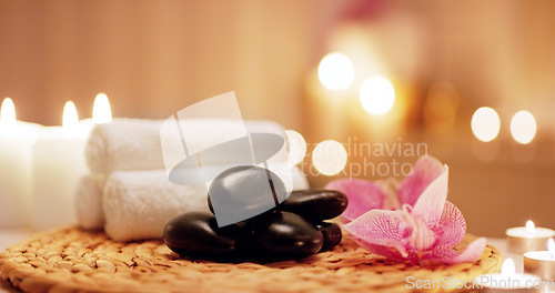 Image of Candles, towels and hot stones at a spa for a massage, healing or luxury treatment therapy. Health, aromatherapy and wellness body care products for a calm, zen or peace atmosphere at a natural salon