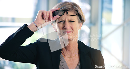 Image of Portrait, doubt and question with a business woman looking confused while standing in her office at work. Corporate, management and leadership with a senior female CEO frowning while lifting glasses