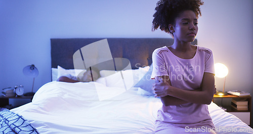 Image of Black couple, bedroom and night with a woman sad while thinking of divorce, stress or depression. Man sleeping in home bed with partner upset about fight, marriage problem and cheating or infertility