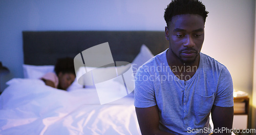 Image of Black couple, bedroom and man with a problem at night while thinking of divorce, stress or depression. A woman sleeping in bed at home with partner upset about fight, marriage or erectile dysfunction