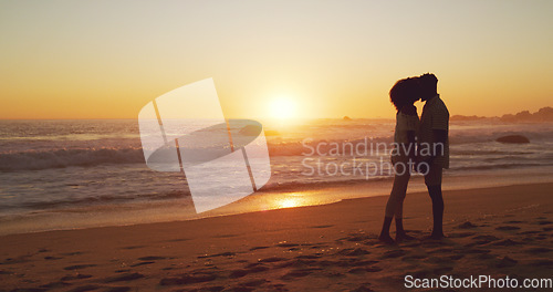 Image of Sunset, kiss and silhouette of couple at the beach for bonding, date or holiday in Bali. Care, dark and a man and woman kissing at the ocean together for love, romance or vacation freedom by the sea