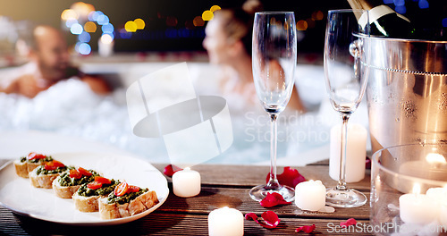 Image of Love, luxury and champagne with hot tub at spa for holiday, romantic vacation and weekend getaway. Couple, marriage and man and woman in bath with food for honeymoon, anniversary and valentines day