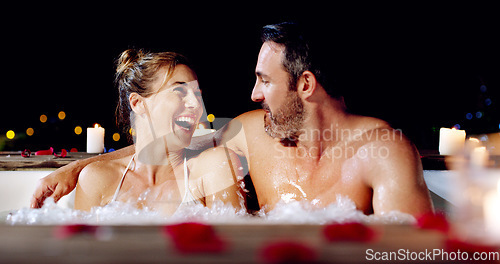 Image of Spa, love and couple in a jacuzzi happy, smile and relax one date night at a wellness resort. Zen, hot tub and man with woman laughing, peace and enjoying a romantic vacation, holiday or anniversary