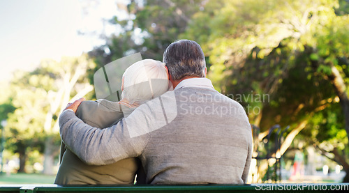 Image of Hug, bench and a senior couple outdoor in a park with love, care and support in marriage. Back of elderly man and woman together in nature for quality time, healthy retirement and freedom to relax