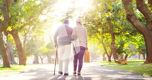 Image of Senior man, daughter and cane outdoor in a park while walking together for support, love and care. Elderly father and a woman walk for a healthy retirement, life insurance and family time in nature