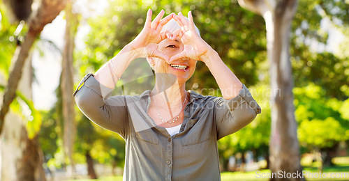 Image of Portrait, heart hands and a woman in a park for summer, retirement break and calm in Australia. Happy, care and a senior person with a shape gesture to show love, happiness and support in nature