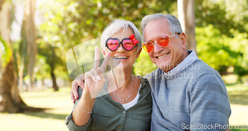 Image of Funny couple, peace sign and portrait outdoor at a park with love, care and hand emoji. A happy senior man and woman with comic sunglasses in nature for happiness, healthy marriage and retirement fun