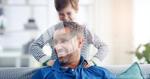 Image of Love, father and son happy smile in living room of their home with lens flare. Happiness or caring, family and male parent with child playing spending quality time or bonding together on couch