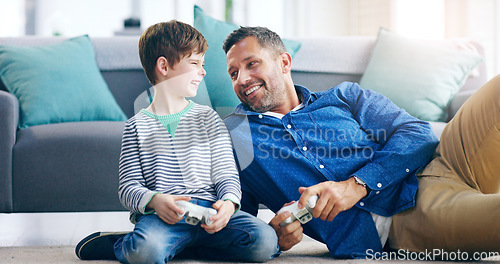 Image of Father, child and playing video games for fun bonding, laughing or time together on living room floor at home. Happy dad and kid smiling with laugh for funny family, son or gaming entertainment